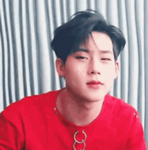 A Close Up Of A Young Man Wearing A Red Shirt And A Necklace . GIF