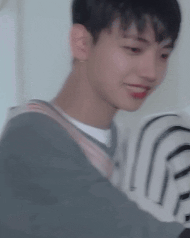 A Close Up Of A Young Man Wearing A Striped Sweater And A White Shirt . GIF