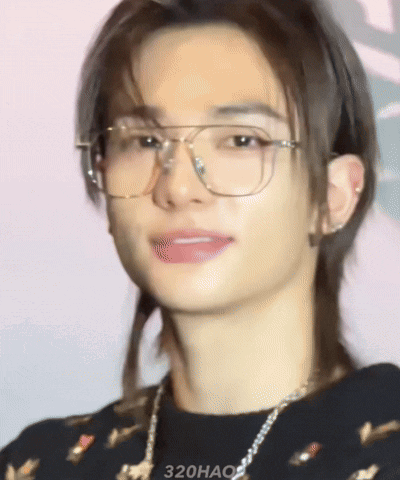 A Close Up Of A Young Man Wearing Glasses And A Necklace GIF