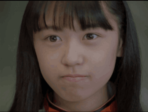 a close up of a young woman 's face with a serious look on her face
