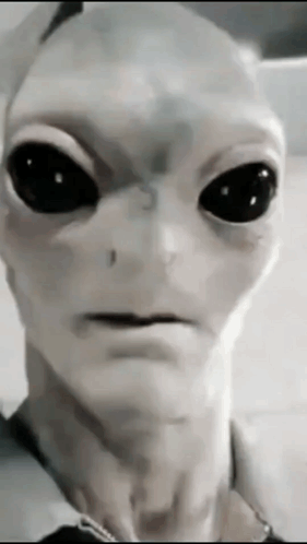A Close Up Of An Alien With Black Eyes GIF