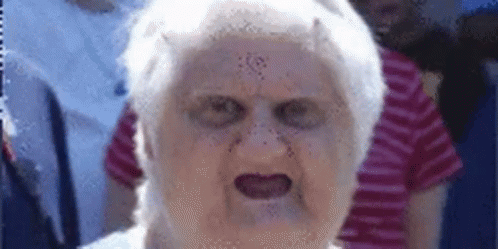 A Close Up Of An Elderly Woman 'S Face With A Devil 'S Face On It . GIF