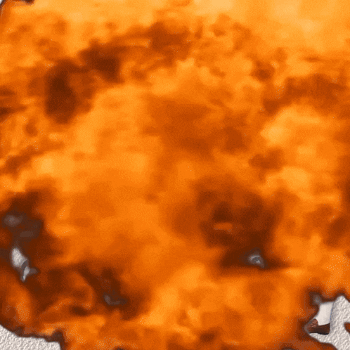 A Close Up Of An Orange Background With A Few Spots GIF