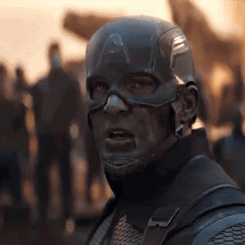 a close up of captain america 's face with a crowd of people in the background