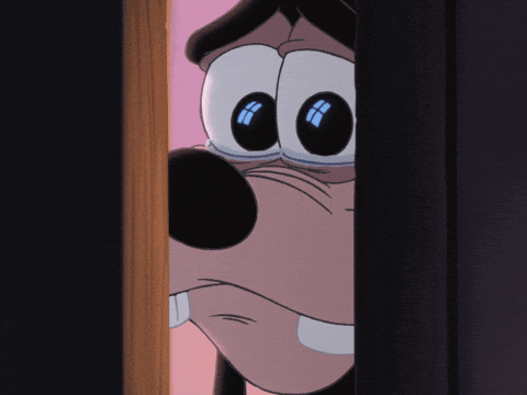 A Close Up Of Goofy 'S Face Peeking Out From Behind A Door GIF