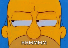 A Close Up Of Homer Simpson 'S Face With The Words `` Hhmmmm '' Written On It . GIF