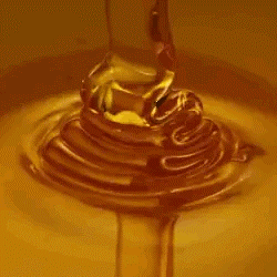A Close Up Of Honey Pouring Into A Bowl Of Liquid . GIF