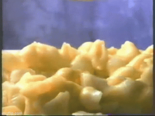A Close Up Of Macaroni And Cheese Being Cooked In A Microwave . GIF