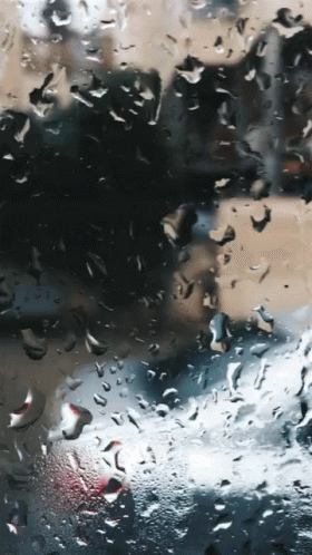A Close Up Of Rain Drops On A Glass Window GIF
