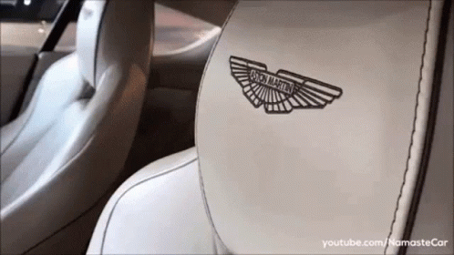 A Close Up Of The Back Seat Of A Car With The Aston Martin Logo On It GIF