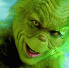 A Close Up Of The Face Of Grinch From The Movie Grinch With A Smile On His Face . GIF