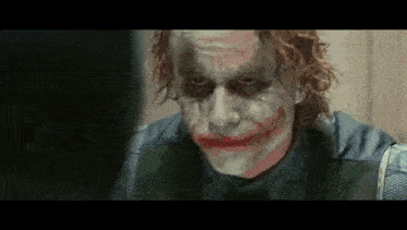A Close Up Of The Joker 'S Face With A Fake Smile GIF