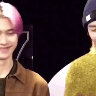 A Close Up Of Two Men Standing Next To Each Other And Smiling . GIF