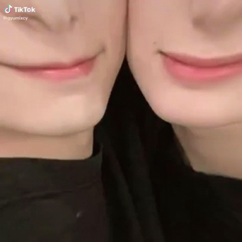 A Close Up Of Two People 'S Faces With Their Mouths Together GIF