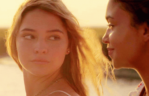 A Close Up Of Two Women Looking At Each Other With The Sun Shining On Their Faces GIF