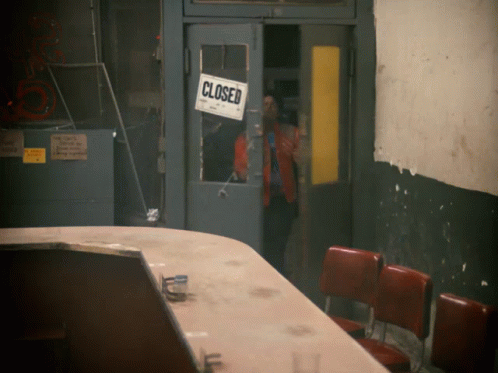 A Closed Sign Hangs On A Door In A Building GIF