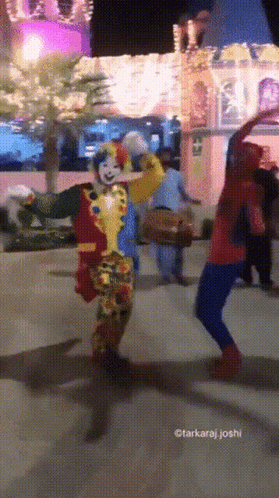 A Clown And A Spiderman Are Dancing In Front Of A Castle GIF