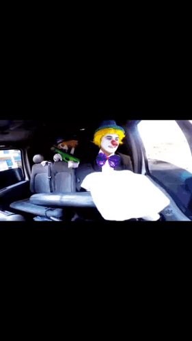 A Clown Is Sitting In The Back Seat Of A Car .. GIF