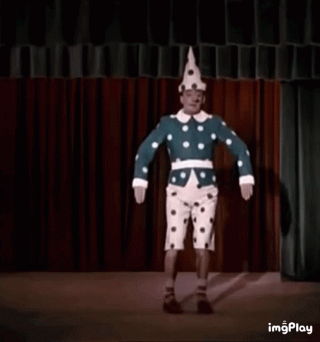 A Clown Is Wearing A Polka Dot Hat And A Blue And White Polka Dot Jacket . GIF