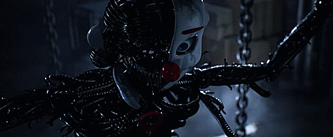 A Clown With A Red Nose Is Tied To A Chain In A Dark Room . GIF