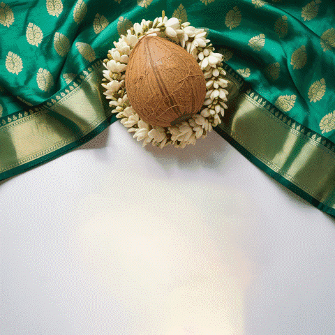 A Coconut Surrounded By White Flowers Sits On A Green Cloth GIF