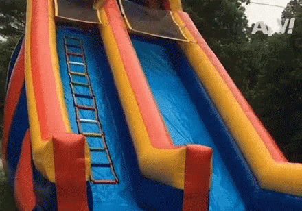 A Colorful Inflatable Water Slide With A Ladder Attached To The Side . GIF