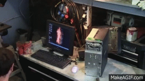 A Computer Is Sitting On A Desk Next To A Broken Computer Tower . GIF