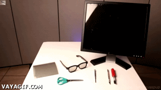 A Computer Monitor Sits On Top Of A White Table With Various Tools And Glasses On It GIF