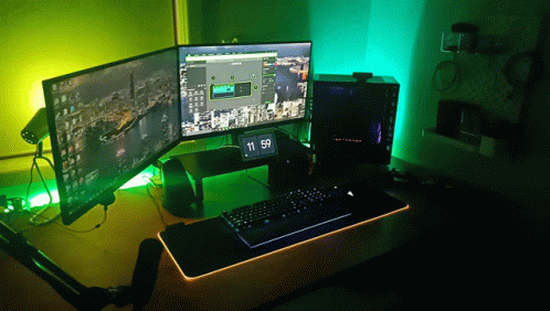 A Computer With Two Monitors And A Clock That Says 11:59 On It GIF