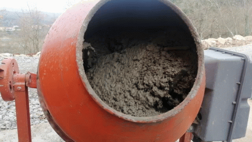 A Concrete Mixer Is Filled With Concrete And Has A Gray Box Behind It GIF