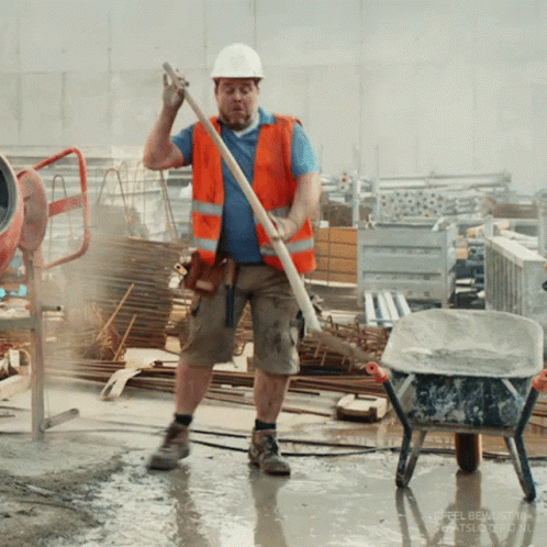 A Construction Worker Is Standing In A Puddle Holding A Stick GIF