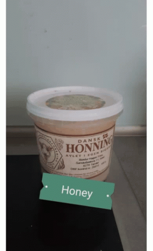A Container Of Dansk Honning Is Sitting On A Table GIF