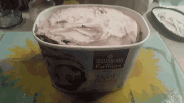 A Container Of Scotsburgh Farmers Ice Cream Is Sitting On A Table GIF
