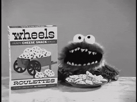 A Cookie Monster Is Eating Wheels Roulettes From A Box . GIF