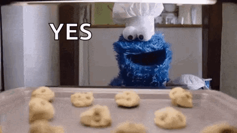 A Cookie Monster Is Standing In Front Of A Pan Of Cookies And Says Yes GIF
