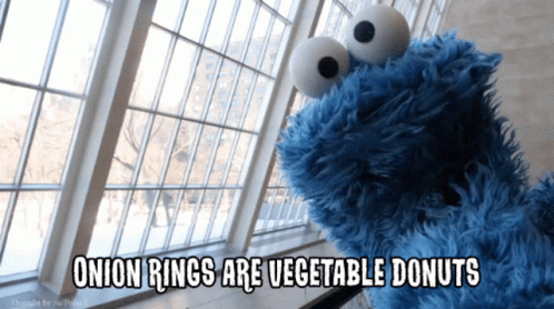 A Cookie Monster Says Onion Rings Are Vegetable Donuts In Front Of A Window GIF