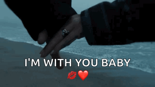 A Couple Holding Hands On A Beach With The Words I 'M With You Baby GIF