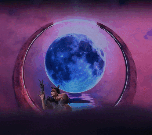 A Couple Kissing In Front Of A Blue Moon GIF