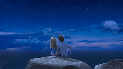 A Couple Looking Up At The Stars In A Blue Sky GIF