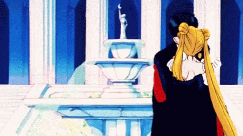 A Couple Of Anime Characters Hugging In Front Of A Fountain . GIF