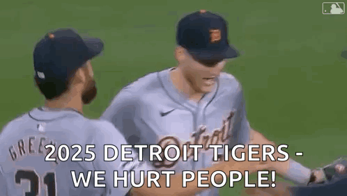 A Couple Of Baseball Players Are Hugging Each Other On A Baseball Field . GIF