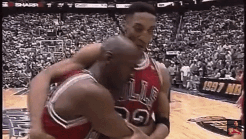 A Couple Of Basketball Players Are Hugging Each Other On A Court . GIF