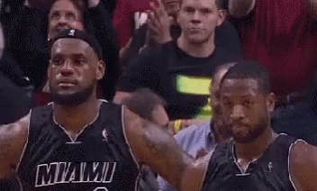 a couple of basketball players are standing next to each other in a crowd .