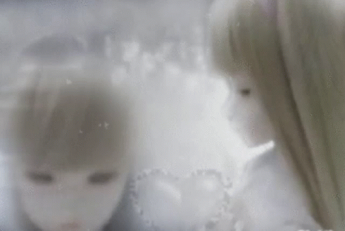 A Couple Of Dolls Are Standing Next To Each Other And Looking At Each Other . GIF