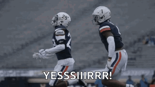 a couple of football players are running on a field and one of them is saying yes .