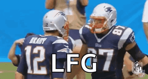 A Couple Of Football Players Are Standing Next To Each Other On The Field . GIF