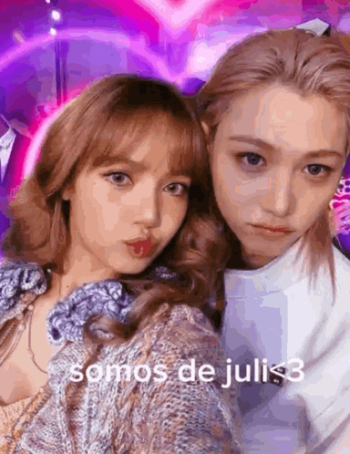 A Couple Of Girls Are Posing For A Picture With The Words Somos De Juli < 3 On The Bottom GIF