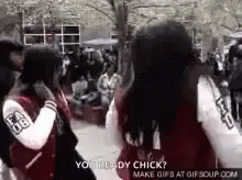 A Couple Of Girls Are Standing Next To Each Other In A Crowded Area . GIF