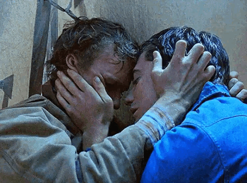 A Couple Of Men Are Hugging Each Other And One Of Them Is Covering His Face With His Hands . GIF