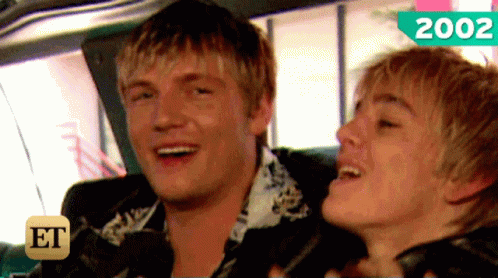 A Couple Of Men Are Sitting In A Car With The Year 2002 On The Bottom GIF